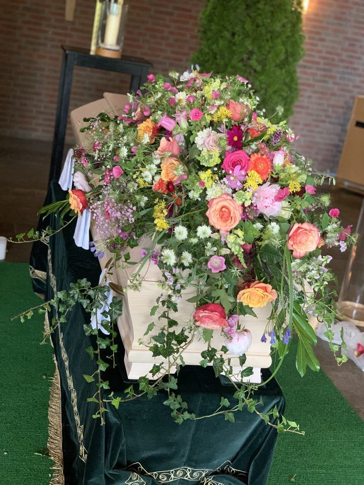 Sargschmuck aus Sommerblumen in kräftigen Farben